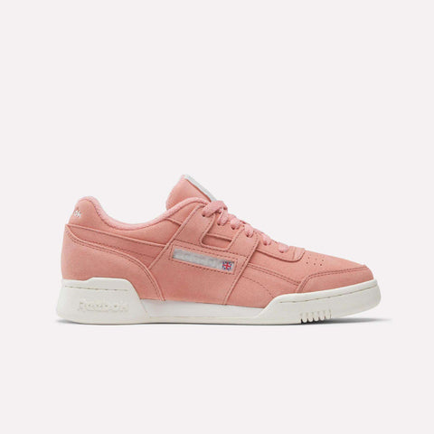 The Reebok Women's Workout Plus Shoes in pink feature white soles, matching pink laces, and a subtle side logo—an 80s-inspired sneaker ideal for women's workout collections, shown against a plain white background.