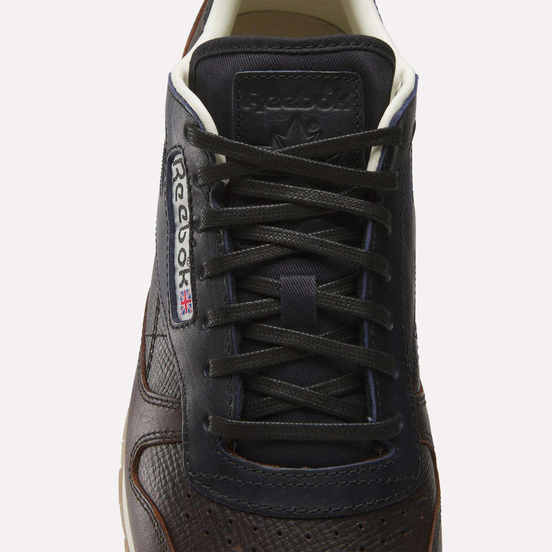 A close-up, top view of the Reebok x C.F. Stead Classic Leather Shoes in dark brown full-grain leather, featuring black laces and the Reebok logo with a UK flag on the side.