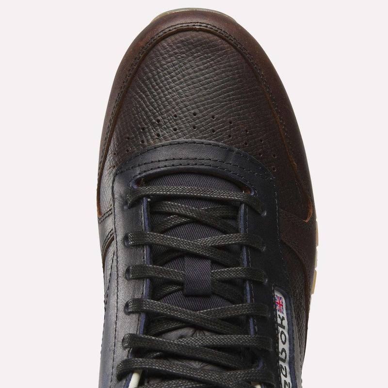 Top view of the Reebok x C.F. Stead Classic Leather Shoes in dark brown and black, featuring a textured full-grain leather upper, black laces, and a visible Reebok logo with the British flag near the tongue.