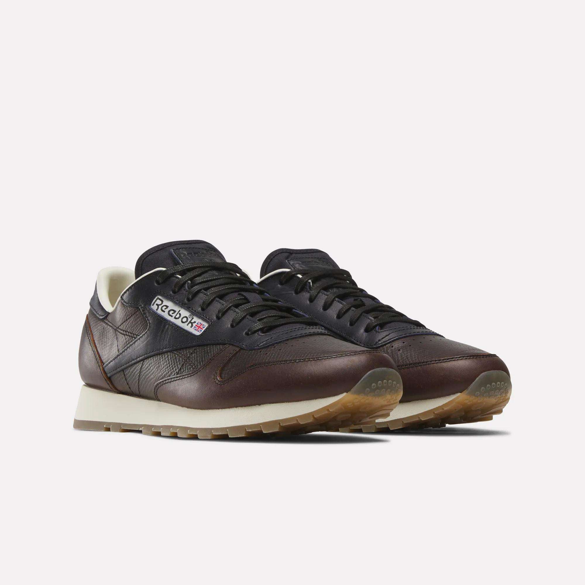 Reebok x C.F. Stead Classic Leather Shoes by Reebok in dark brown and black feature beige soles, white lining, the Reebok logo, and premium full-grain leather uppers, shown against a plain light background.