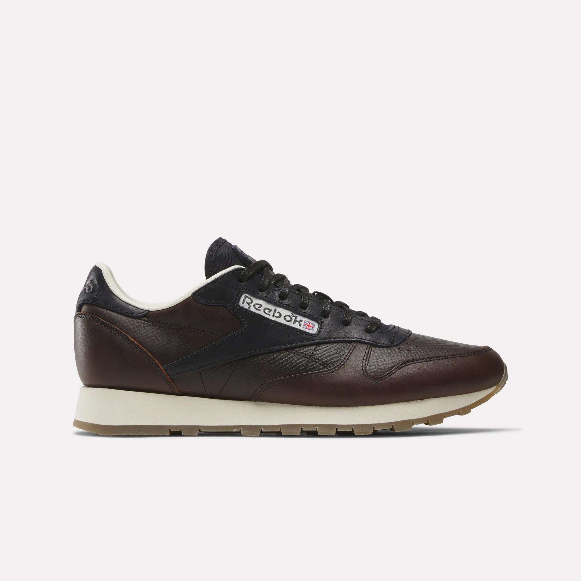 Side view of the Reebok x C.F. Stead Classic Leather Shoes in dark brown full-grain leather, featuring black laces, a beige midsole, and a brown rubber outsole. The Reebok logo and Union Jack are visible on the side.