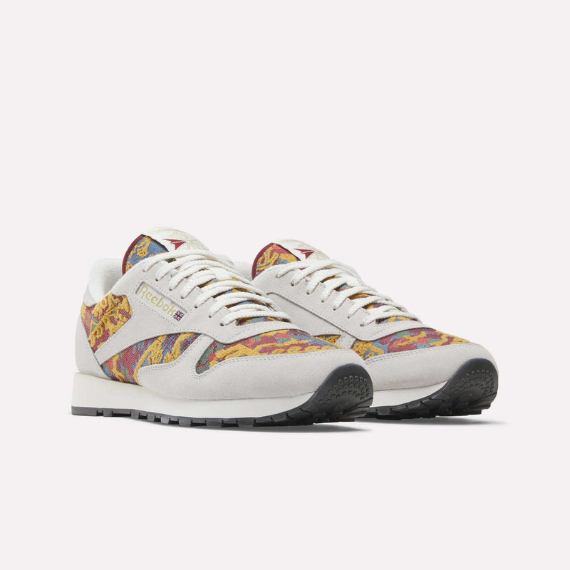 The Reebok Classic Leather 1983 Vintage Shoes feature white suede and multicolored paisley fabric panels, displayed against a plain white background.