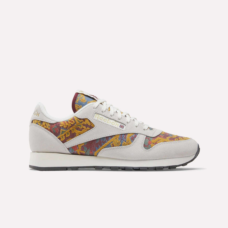 The Reebok Classic Leather 1983 Vintage Shoes feature off-white suede overlays and multicolored paisley-patterned fabric on the sides, toe, and tongue, finished with white laces and a black outsole.
