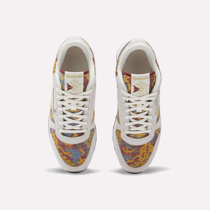 Top view of Reebok Classic Leather 1983 Vintage Shoes, featuring white laces and a multicolored paisley-like pattern in red, yellow, blue, and green with the Reebok logo on each tongue for a classic look.