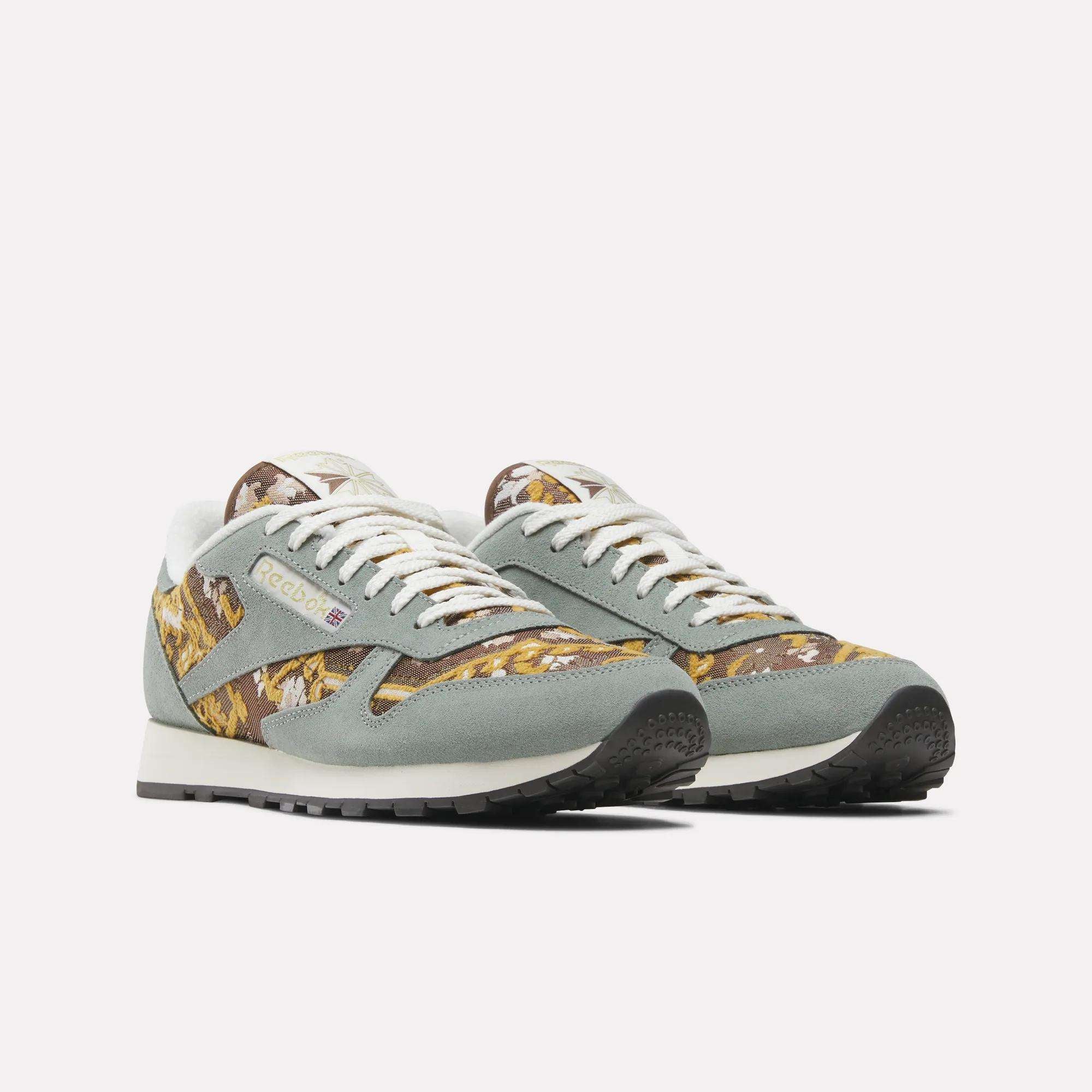 The Reebok Classic Leather 1983 Vintage Shoes feature light gray suede details, white laces, a yellow, brown, and white Persian rug-inspired pattern, black soles, and a retro design.