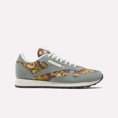 A single Reebok Classic Leather 1983 Vintage Shoe with a light blue-green suede upper, brown, gold, and cream floral tapestry panels, white laces, and a white midsole with black outsole is shown in side view on a plain background.