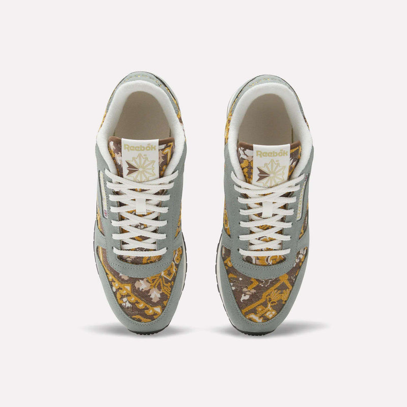 Top view of Reebok Classic Leather 1983 Vintage Shoes with light gray overlays, white laces, and a gold and brown patterned fabric on the toe box and sides, plus the Reebok logo on the tongue.