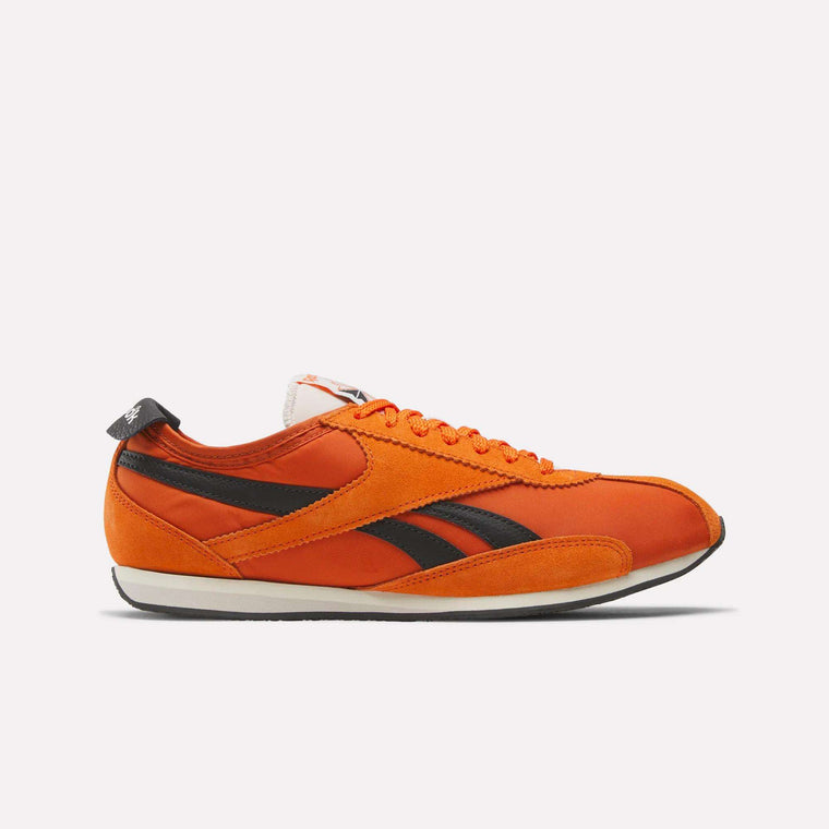 Reebok R400 Shoes feature a bright orange retro design with black stripe accents, orange laces, a white midsole, and black outsole. The low-profile sneakers are displayed in side view against a plain white background.