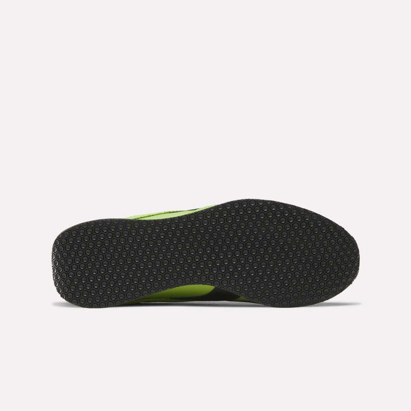The image shows the sole of Reebok R400 Shoes, black with a textured hexagonal pattern. Green from the upper appears at the edges, emphasizing their classic retro style against a plain white background.