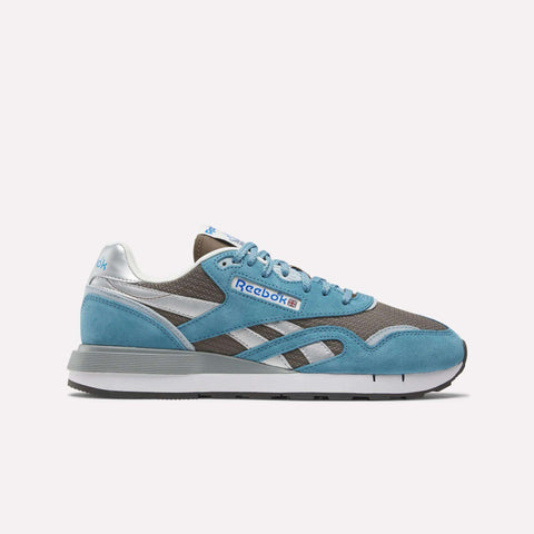 The Reebok Classic Nylon 89 Shoes feature blue suede, silver accents, and gray mesh panels, plus a cushioned midsole for comfort. Blue laces and a white-gray sole complete the vintage running look on a plain white background.
