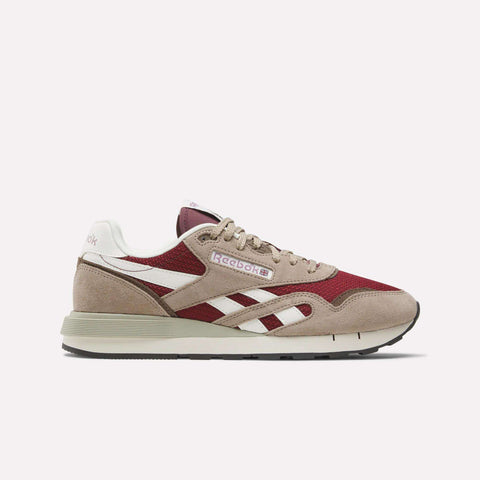 The Reebok Classic Nylon 89 Shoes feature beige suede and red mesh, white and beige side stripes, a cushioned midsole, beige laces, and a beige-gray sole, displayed from the side against a plain white background.