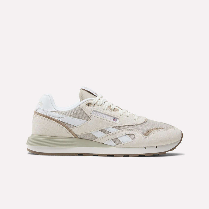 The Reebok Classic Nylon 89 Shoes feature beige and white suede and mesh panels, cushioned midsole, retro design, white laces, Reebok branding, and a low-profile rubber sole shown against a plain background.