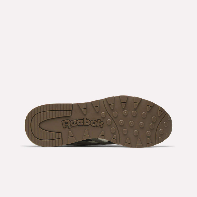 The image shows the bottom view of a brown Classic Nylon 89 Shoes sole by Reebok, featuring circular and rectangular grip patterns with the Reebok logo embossed in the center.