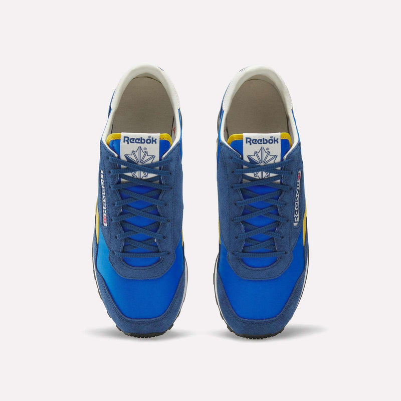 A pair of blue Reebok Aztec II Shoes with suede and mesh uppers, yellow and white accents, plus white tongue labels showing the Reebok logo, viewed from above on a white background—ideal for vintage running shoe fans.
