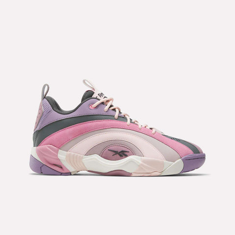 The Reebok Shaqnosis Low Shoes are stylish low-cut basketball sneakers with pink, purple, and lavender panels, white laces, Hexalite cushioning for comfort, and the Reebok logo on the side and tongue, displayed on a plain white background.