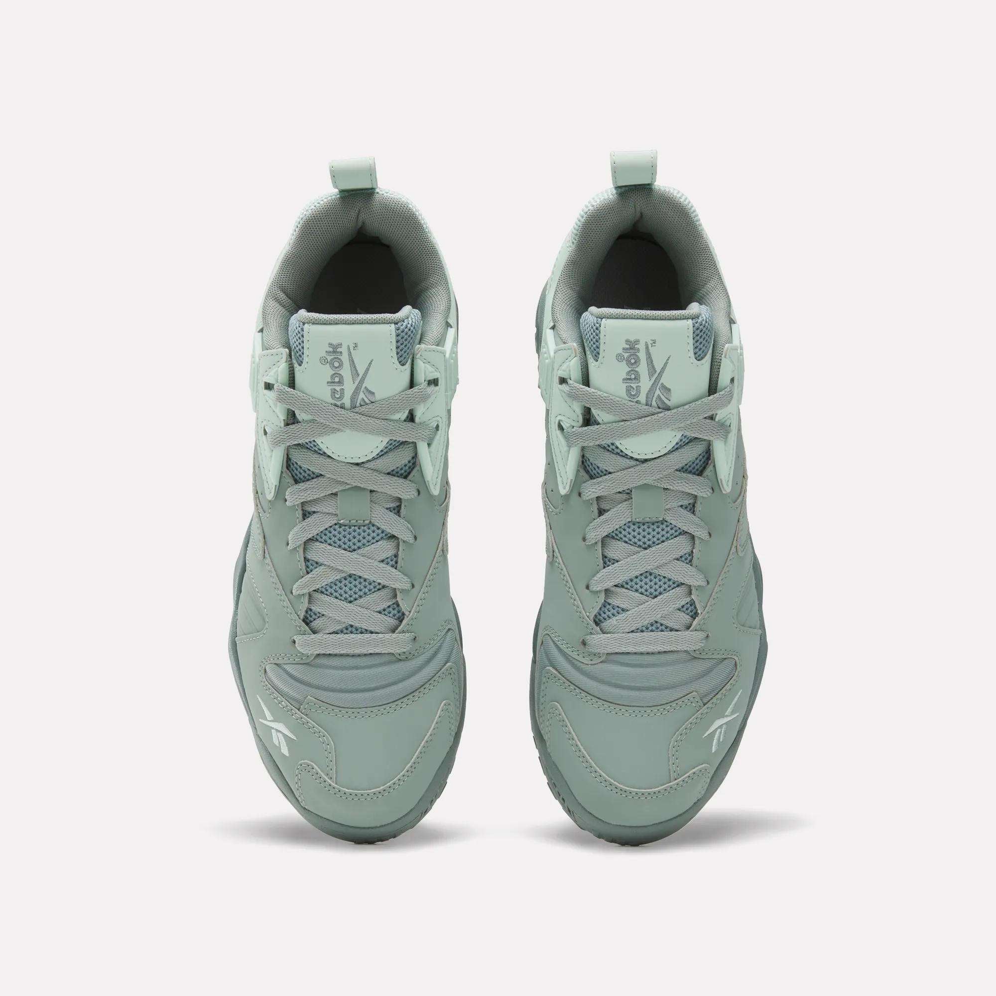 Top view of Reebok Brutus Low Shoes in light green with laces, mesh detailing, and Reebok logos on the tongue and toe. Features an EVA midsole for comfort, shown on a plain white background.