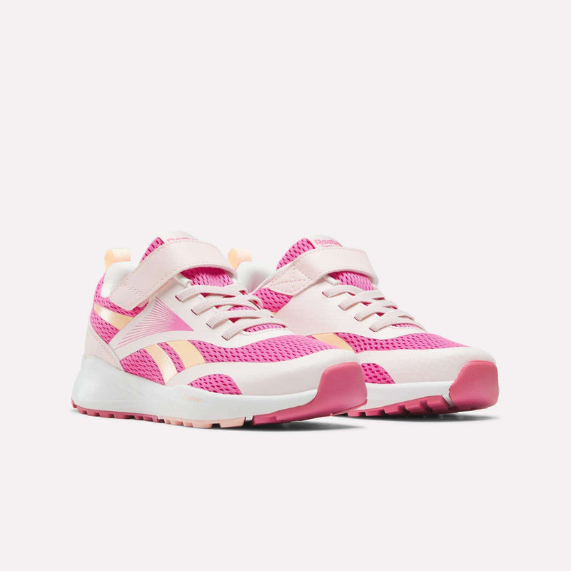 A pair of Reebok Energen Running Shoes for little kids, featuring pink and white mesh uppers, Velcro straps, laces, pink outsoles, and peach accents—all showcased against a plain white background.