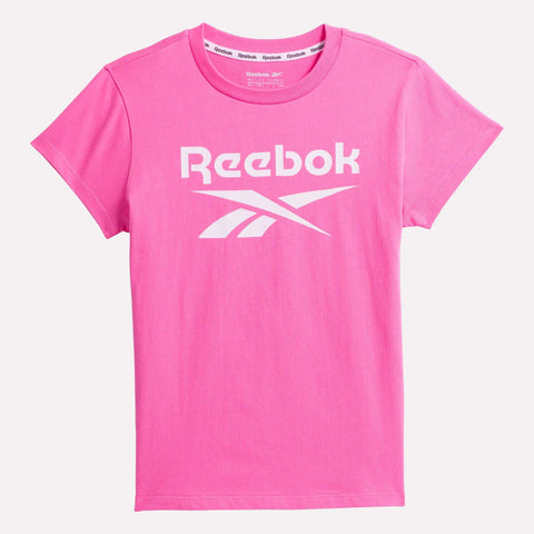 The Reebok Kids' ID Big Logo Tee is a soft cotton girls' t-shirt in plain pink with short sleeves and the Reebok logo and name printed in white on the front.