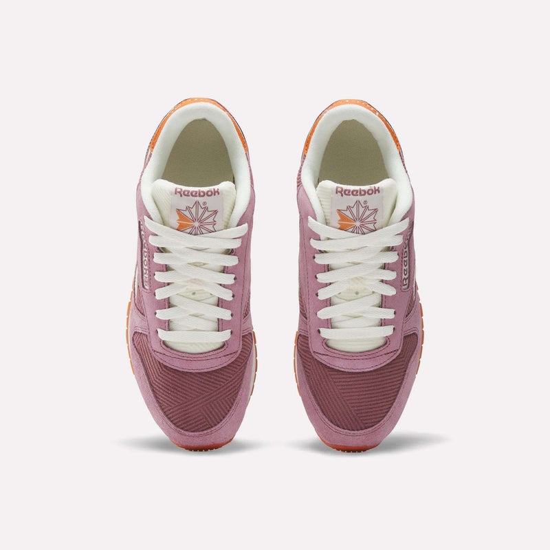 Top view of Reebok Women's Classic Leather Shoes in pink and maroon with white laces, white lining, corduroy accents, and gum soles, shown on a plain light background.