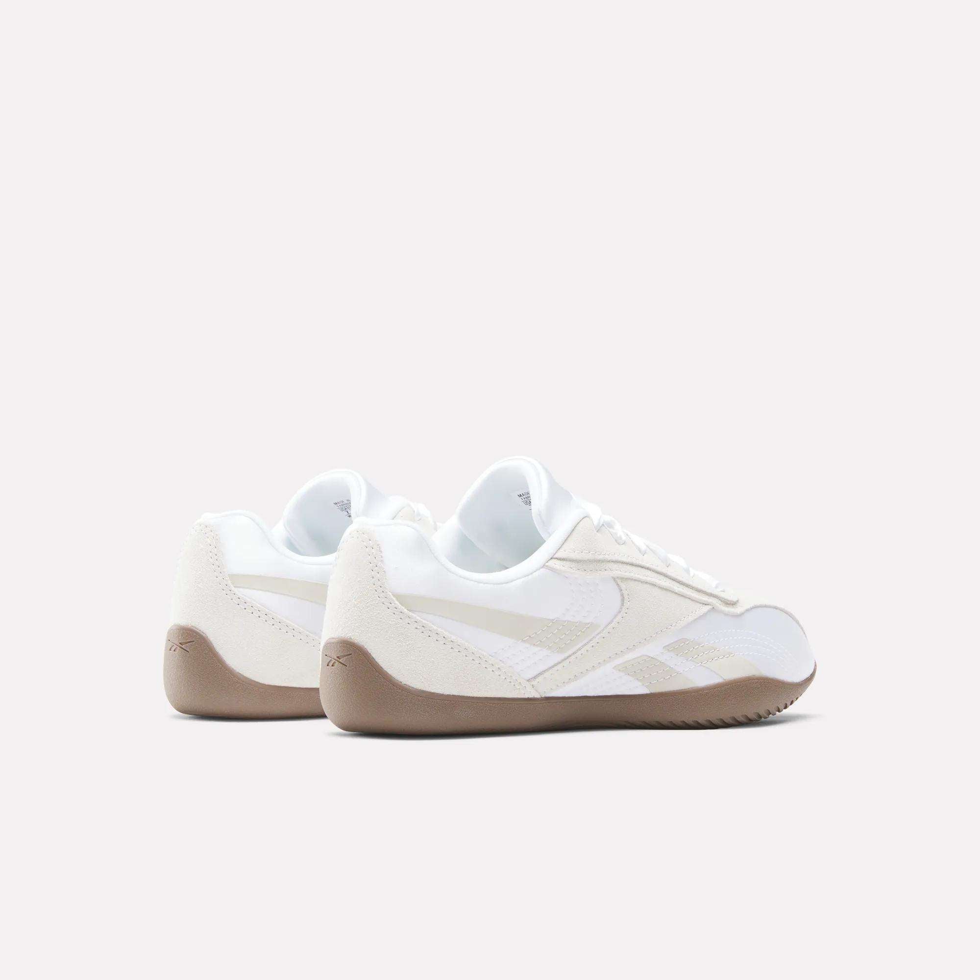 A pair of Reebok Women's Ultra Lo Shoes in white and beige with gum soles is shown from the back and side against a plain light background.