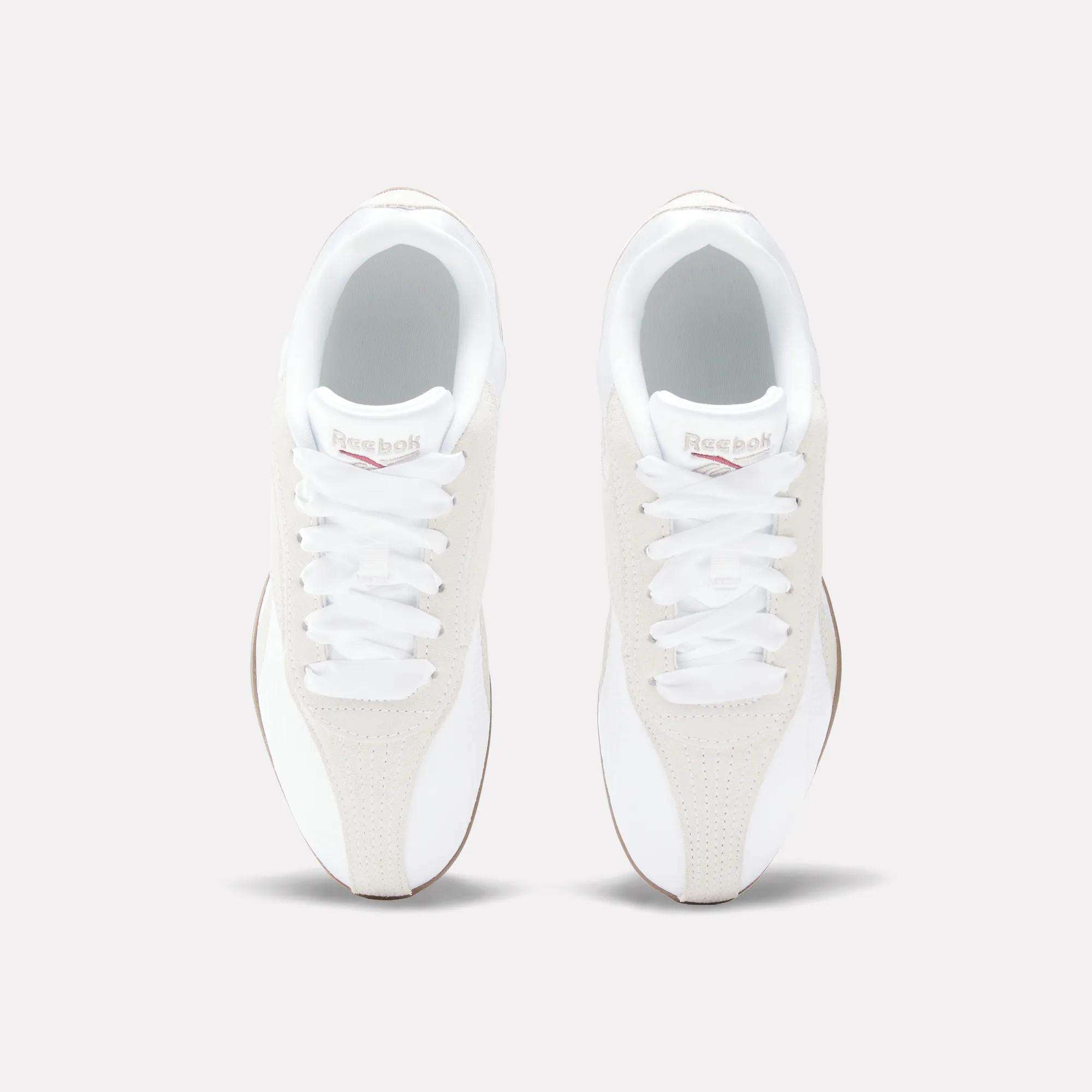 Top view of Reebok Women's Ultra Lo Shoes in white with beige suede accents, white laces, and the Reebok logo on the tongue, highlighting their sport-inspired style against a light background.