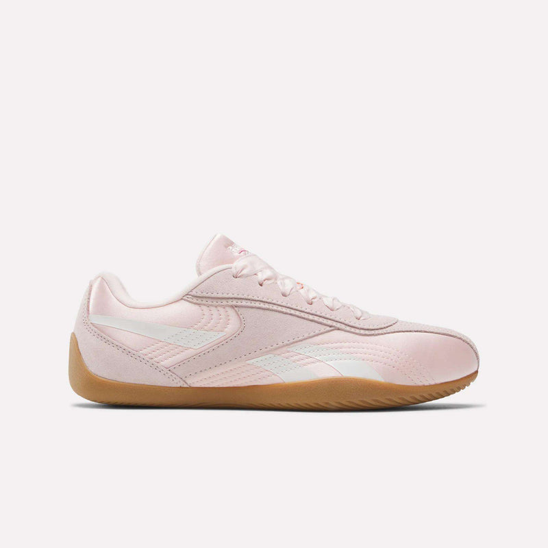 The Reebok Women's Ultra Lo Shoes feature a light pink low-profile design with white accents and a tan rubber sole, displayed from the side on a plain white background.