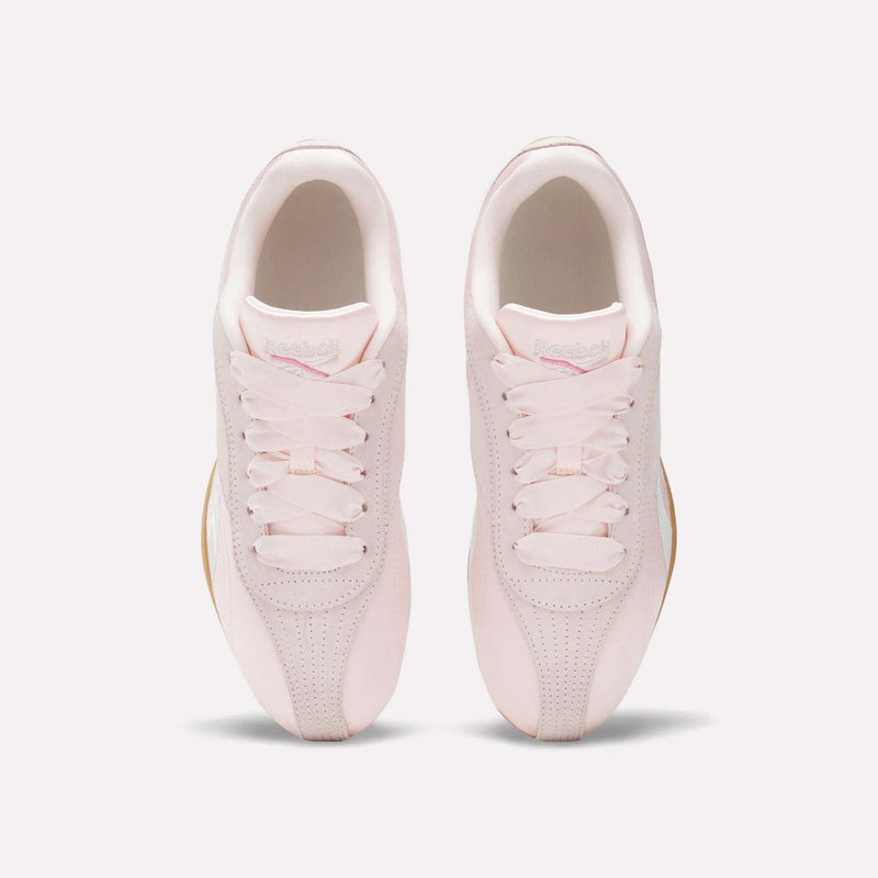 A pair of Reebok Women's Ultra Lo Shoes in light pink, shown from above with laces, perforated toe details, and tan outsoles for a sporty look.