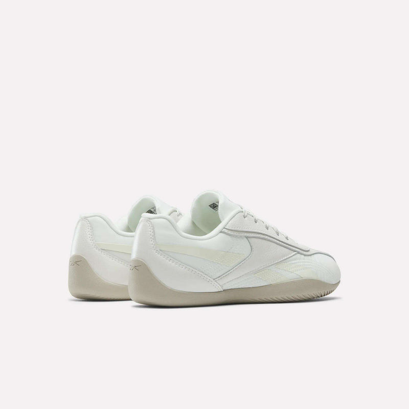 A pair of Reebok Women's Ultra Lo Shoes in white with beige soles, shown from back and side views against a plain white background, highlighting their low-profile design.