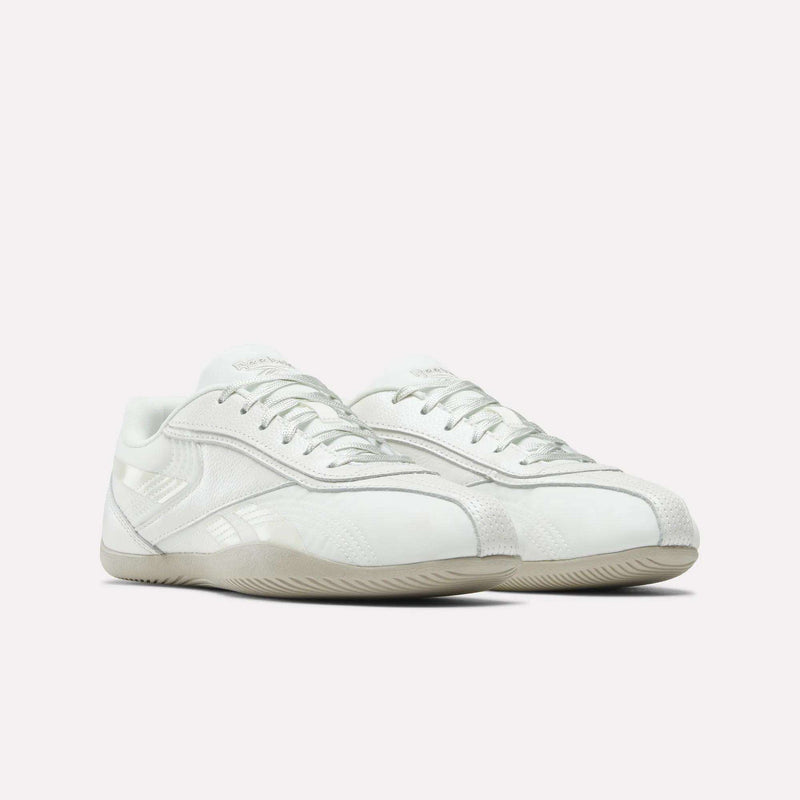 The Reebok Women's Ultra Lo Shoes feature a white low-profile design with subtle light grey accents, textured details, and off-white rubber soles, shown against a plain light background.
