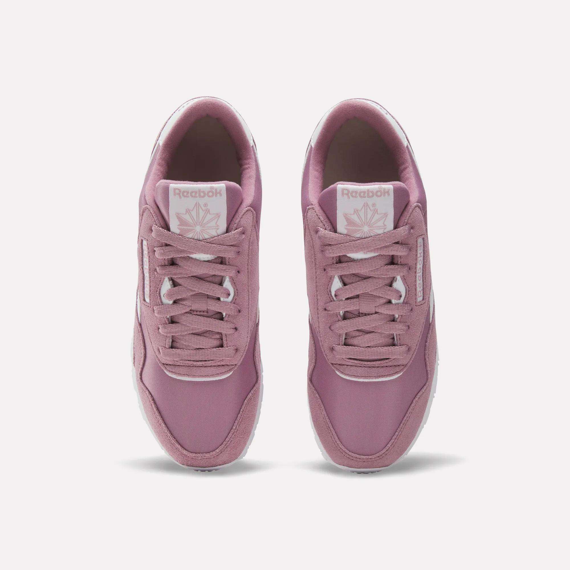 A pair of Women's Classic Nylon Shoes by Reebok in mauve pink retro style, shown from above with visible laces, branded tongue, and white outsoles on a light background.