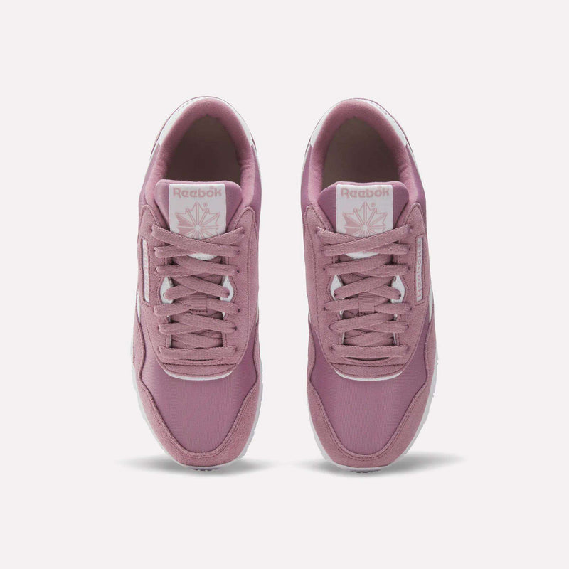 A pair of Women's Classic Nylon Shoes by Reebok in mauve pink retro style, shown from above with visible laces, branded tongue, and white outsoles on a light background.