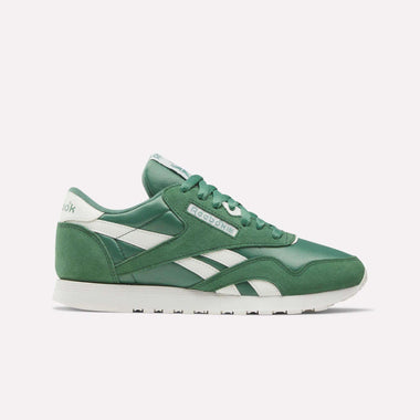 The Women's Classic Nylon Shoes by Reebok are shown in green with white accents and sole, featuring retro nylon and suede materials. Displayed in a side profile against a plain white background.