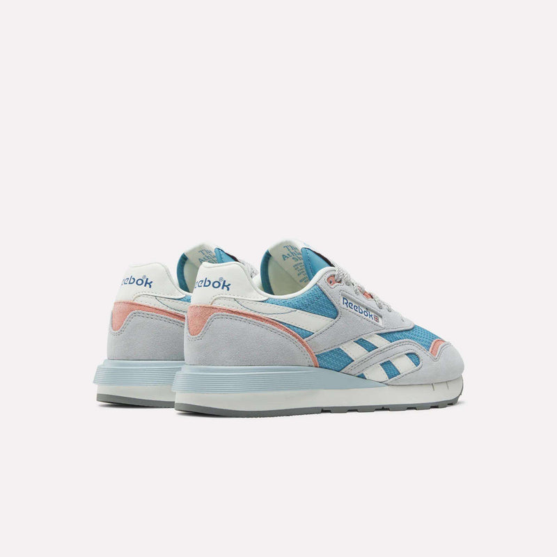 The Reebok Women's Classic Nylon 89 Shoes in white, light blue, and pink suede and leather are shown from the back and side on a light background, with the Reebok logo visible on the heel and side.