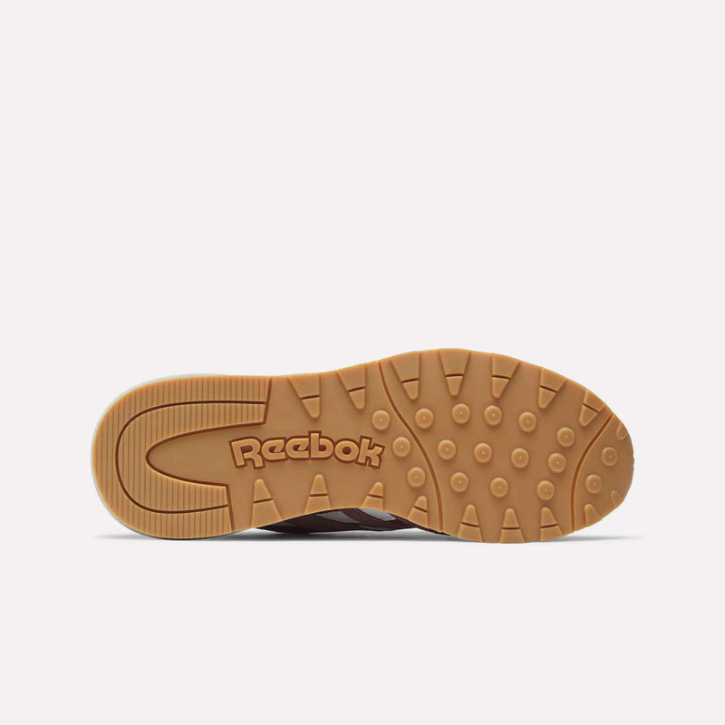 The image shows the gum-colored outsole with circular treads of the Reebok Women's Classic Nylon 89 Shoes, featuring the Reebok logo prominently in the center against a plain white background, highlighting their retro style.