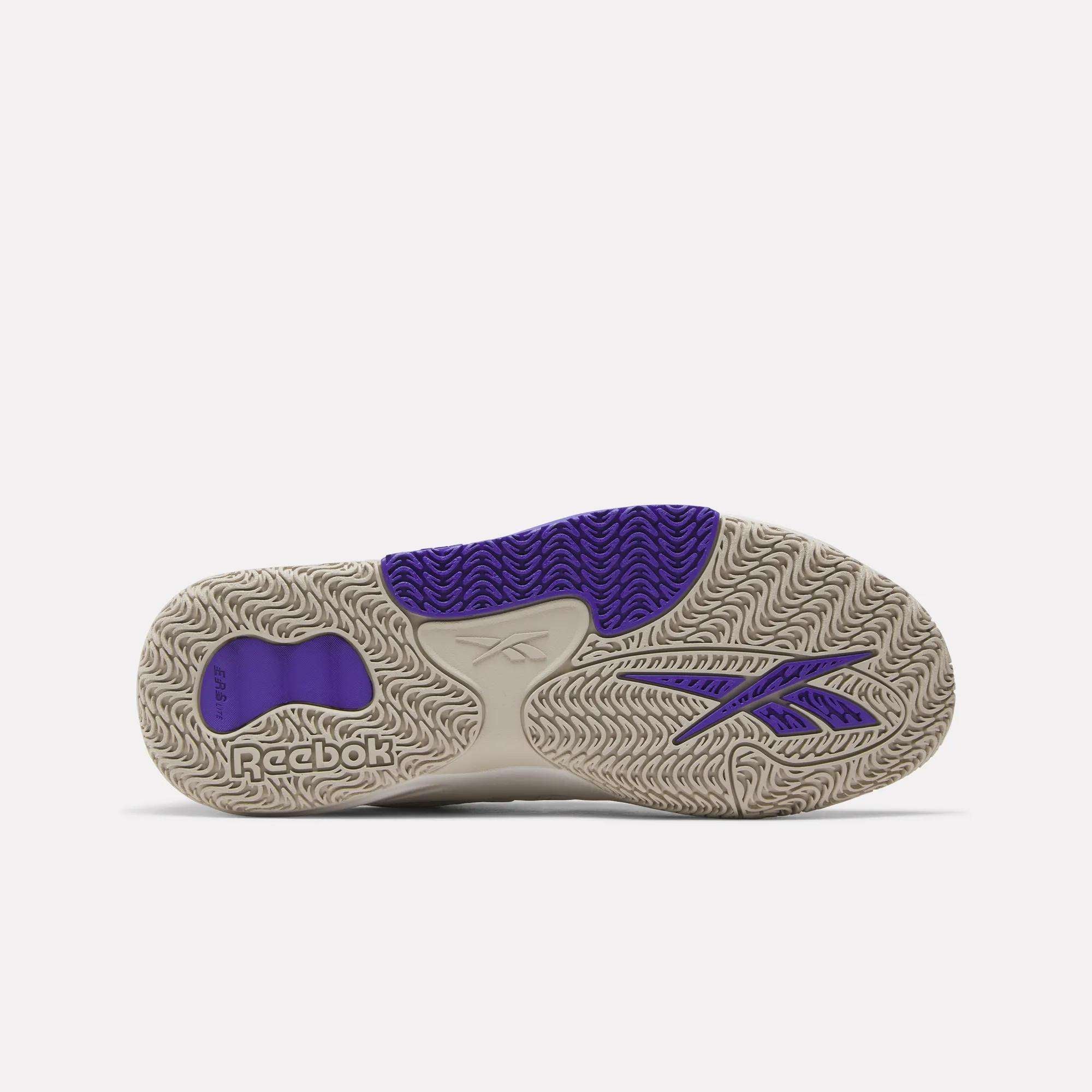 The image shows the sole of Reebok Engine LT Shoes, mainly beige with detailed wavy tread patterns and purple accents, including the Reebok logo and signature on the side and heel—ideal for fans of cushioned sneakers.