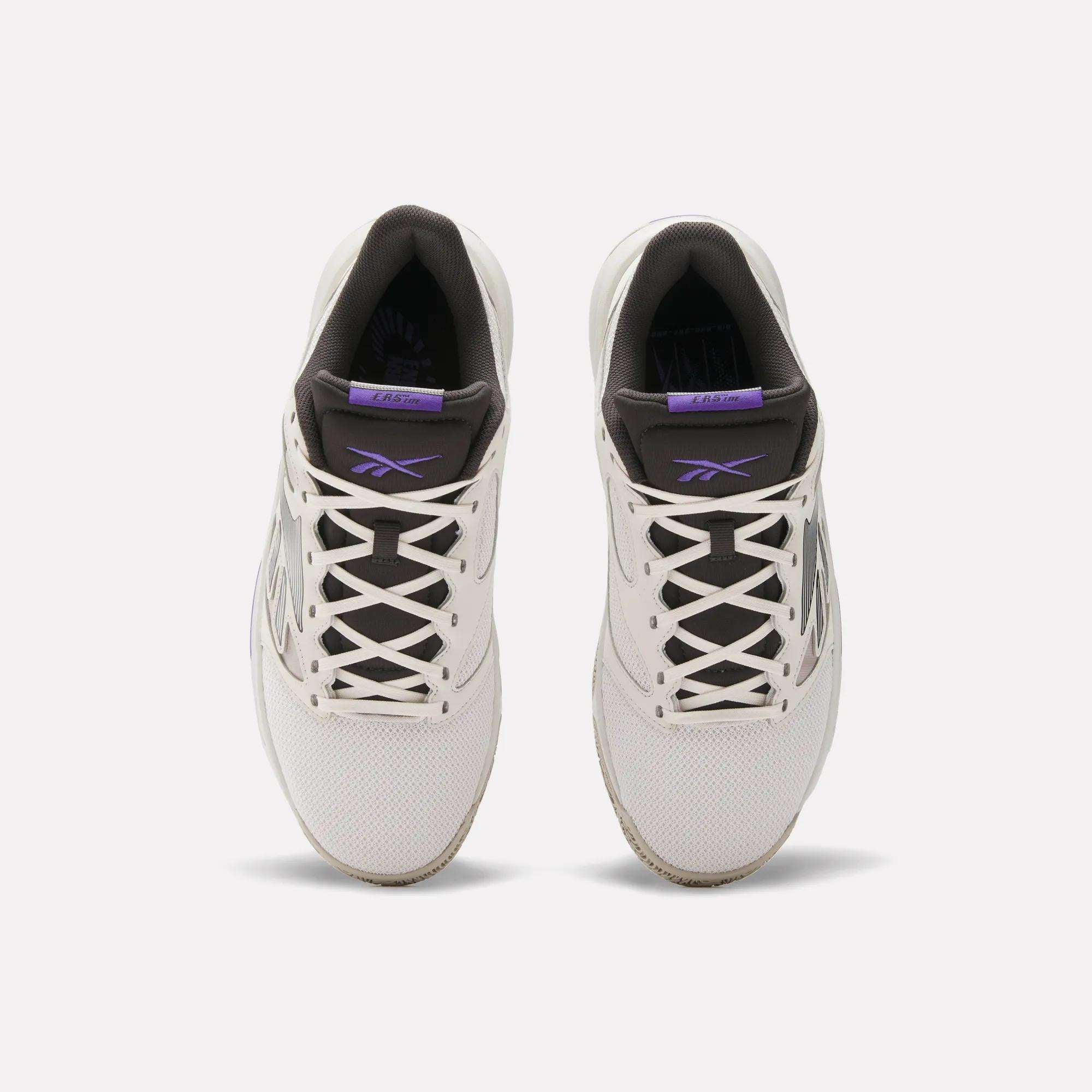Top view of a pair of Reebok Engine LT Shoes in white with black and purple accents, white laces, and visible Reebok logos on the tongue and side. These cushioned sneakers are shown side by side on a plain white background.