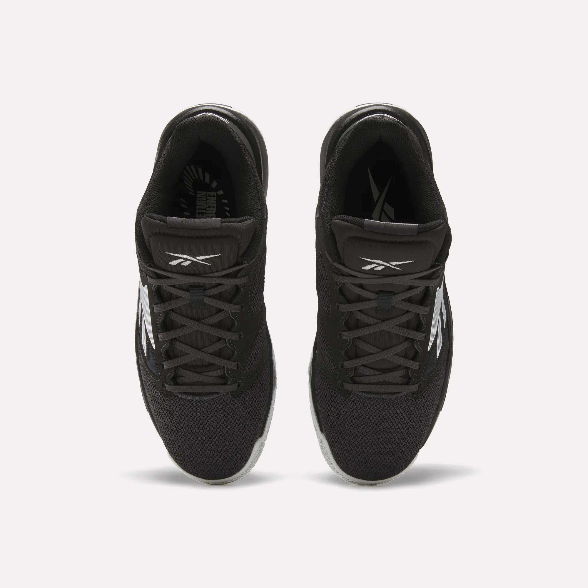 Top view of a pair of Reebok Engine LT Shoes in black with white logos and accents, featuring mesh uppers and black laces, placed side by side on a white background.