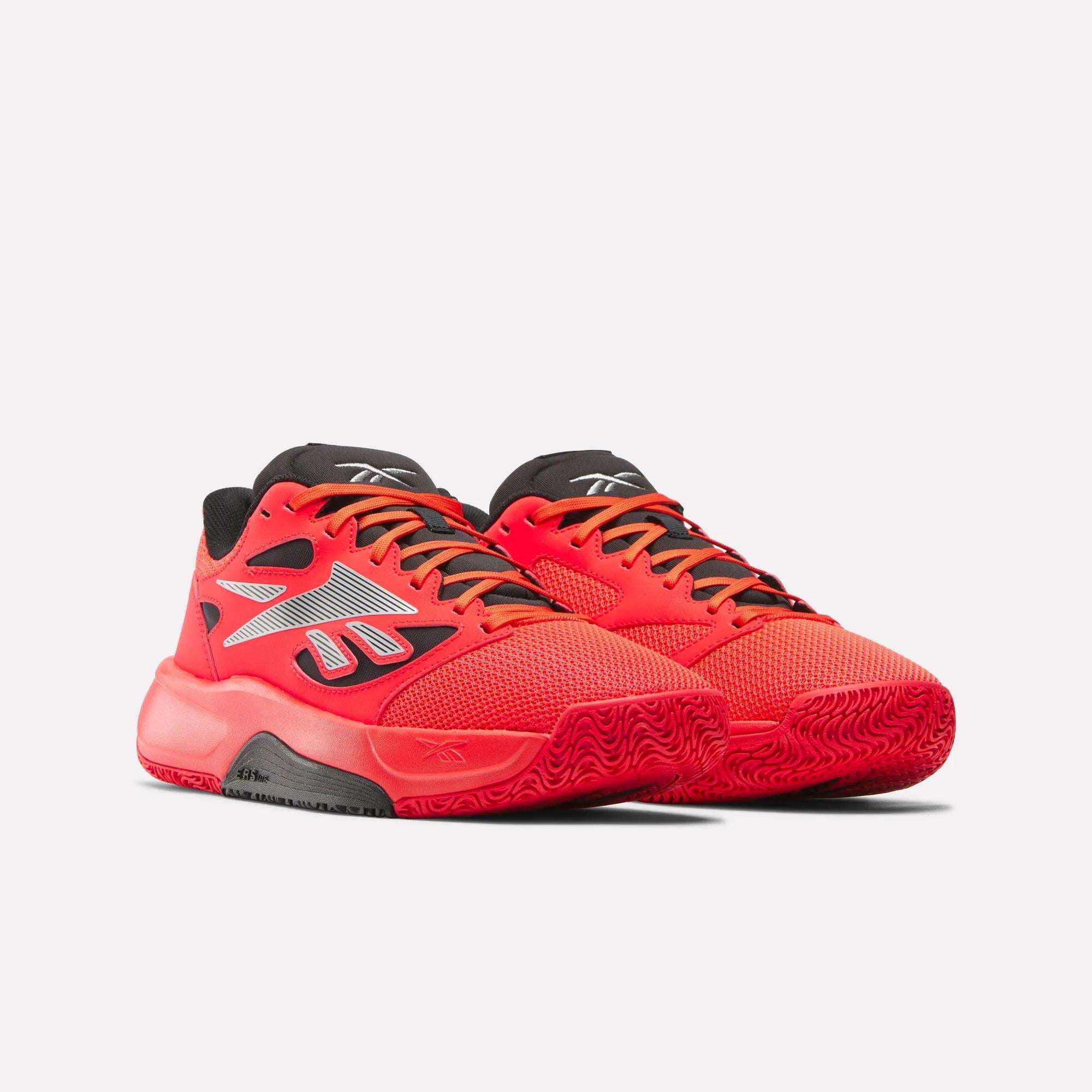 A pair of Reebok Engine LT Shoes in bright red with black and gray accents, black soles, and white Reebok logos on the sides, displayed against a plain light background.