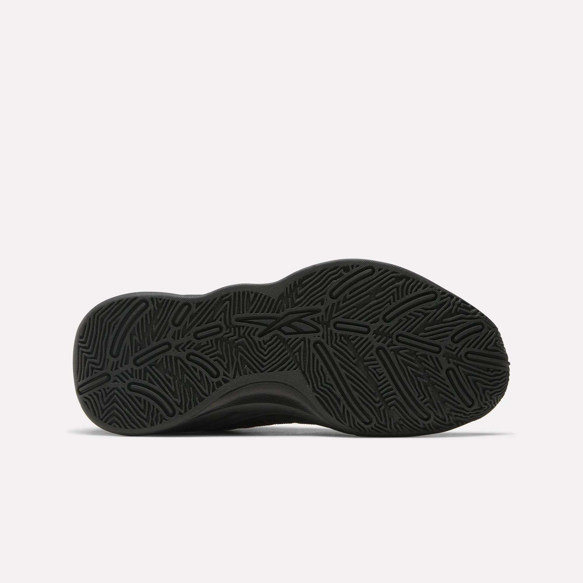 The image displays the black, textured rubber outsole of Reebok’s Press Retro Basketball Shoes, highlighting its intricate wavy tread pattern for responsive performance, photographed on a plain white background.