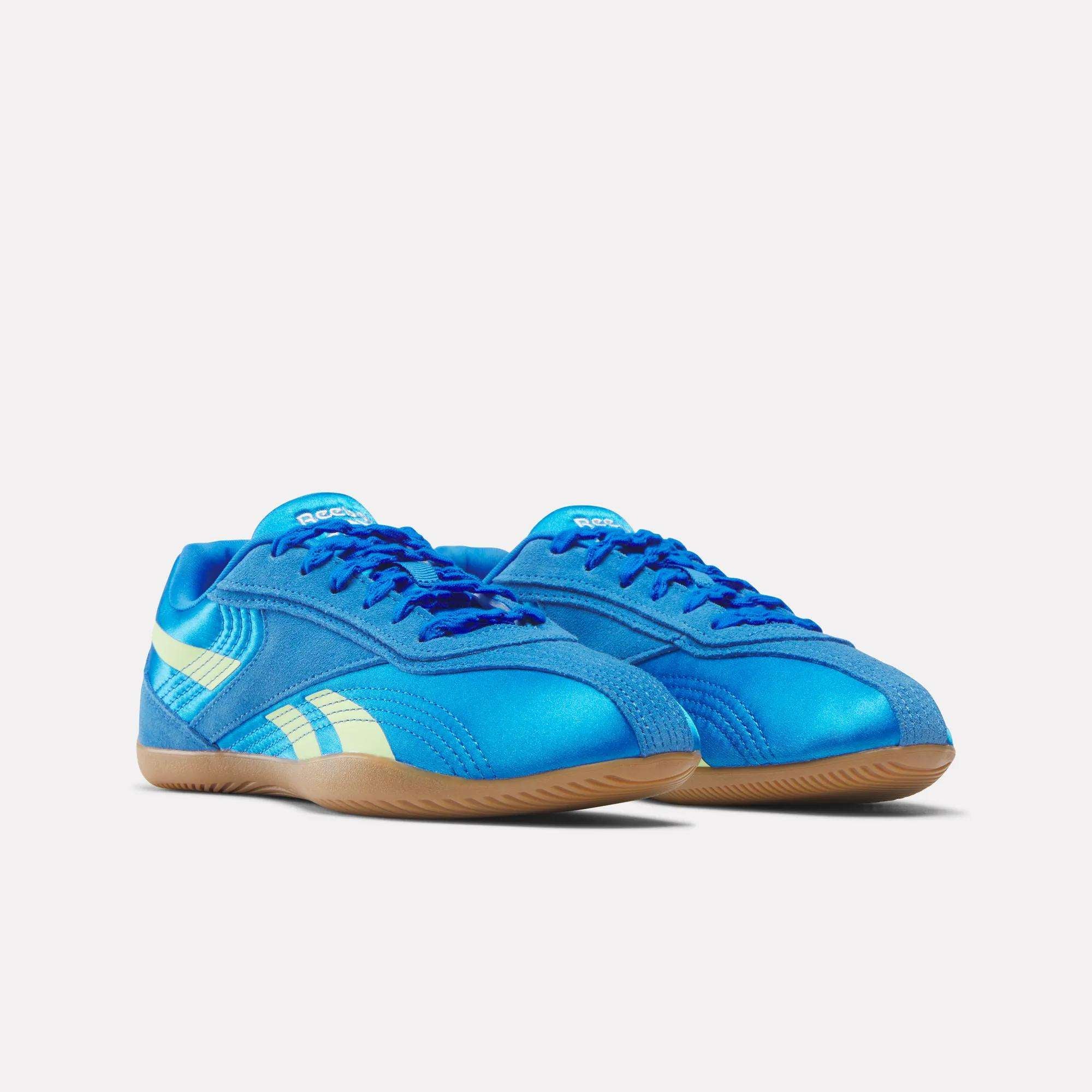 The Reebok Women's Ultra Lo Shoes feature a bright blue design with cream stripes and gum-colored soles, shown side by side on a white background. Lightweight and stylish, they provide comfort and a modern look.