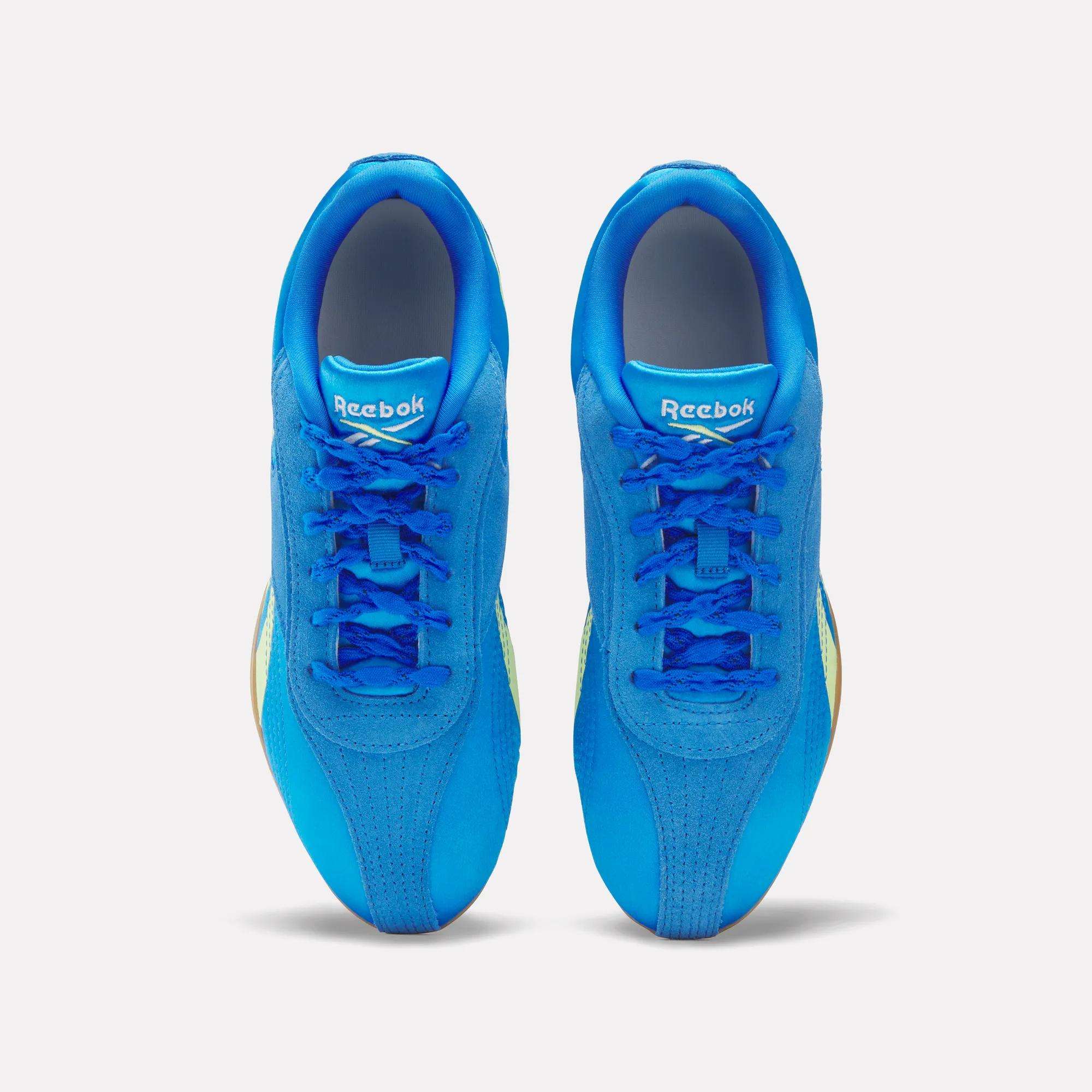 A pair of Women's Ultra Lo Shoes by Reebok in bright blue, shown from above with laces, logoed tongues, and rounded toe caps. These lightweight sneakers are displayed on a plain white background.