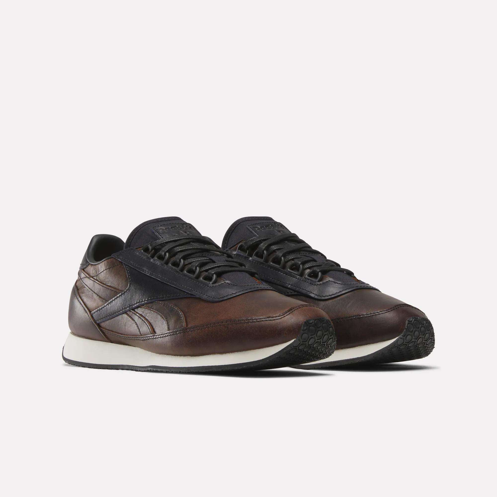 The Reebok Camargue x C.F. Stead Shoes feature full-grain leather uppers, dark navy accents, white midsoles, and black textured outsoles, shown on a plain white background.