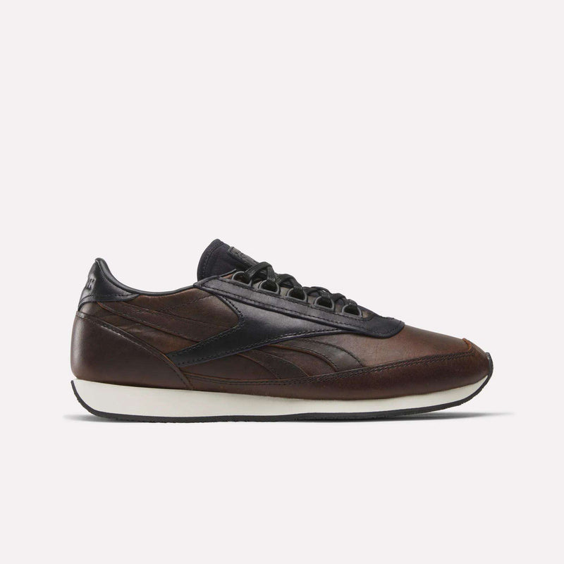 The Reebok Camargue x C.F. Stead Shoes, shown in side profile on a plain white background, feature brown full-grain leather with black accents and laces, a dark navy heel and sole detail, plus a white midsole in archival style.
