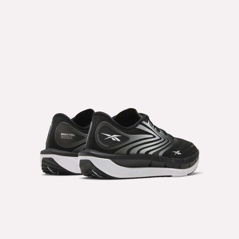 A pair of Reebok Women's FloatZig Tread Running Shoes in black with breathable mesh uppers, white soles, and silver accents are shown on a plain white background, highlighting their comfort for treadmill workouts.