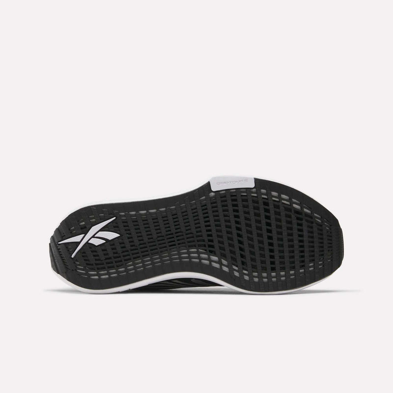 The image displays the black rubber outsole of Reebok’s Women's FloatZig Tread Running Shoes, with a grid-patterned tread, white Reebok logo by the heel, and a white midsole accent—offering ideal traction for treadmill workouts.