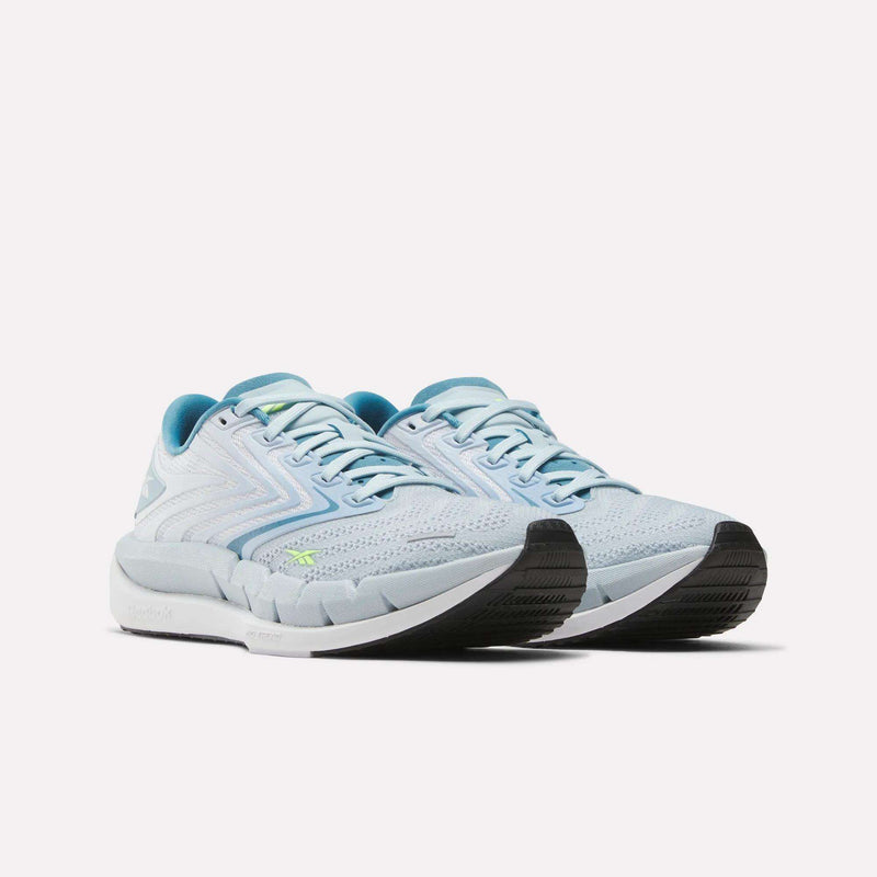 Reebok Women's FloatZig Tread Running Shoes in light blue and white, featuring black soles, blue accents, and a breathable mesh upper—ideal for treadmill workouts—are displayed against a plain white background.