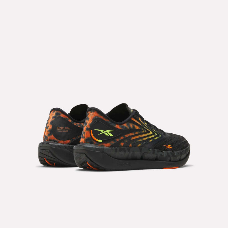 A pair of Women's FloatZig Tread Running Shoes by Reebok featuring a black mesh upper, orange and yellow gradient accents, and neon green side logos, shown heels forward on a plain white background.