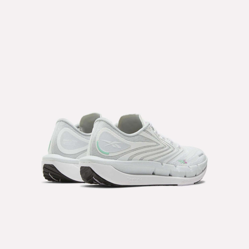 Two white Reebok Women's FloatZig Tread Running Shoes with light gray and green accents are placed back to back on a white background, displaying their side and rear details. These treadmill shoes feature breathable mesh uppers and textured soles.