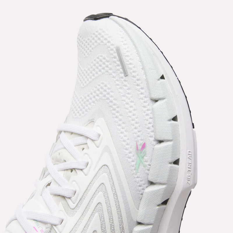 Close-up of a white Reebok Women's FloatZig Tread Running Shoe featuring zigzag textured patterns, a distinctive Zig sole, breathable mesh upper, white laces, and subtle pastel logo—ideal for treadmill running.