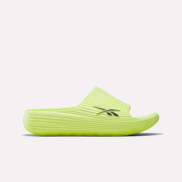 The Reebok DMX Recovery Walking Slides feature a bright yellow-green color, ribbed texture, open toe, black side logo, and moving air cushioning for comfort, shown against a plain white background.